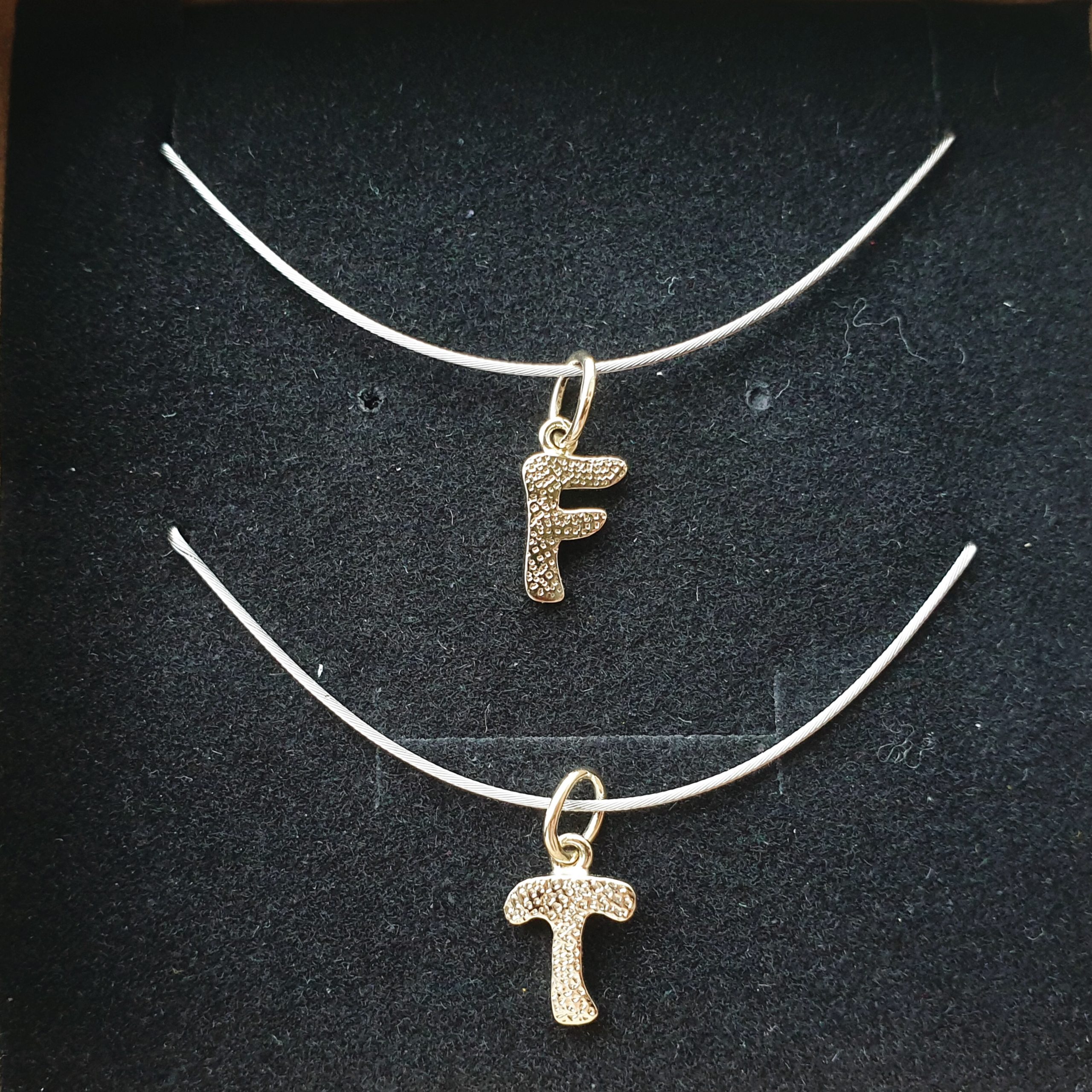 Kettenanhänger aus Gold in Form von Buchstaben in Münchberg